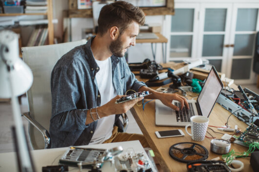 Elektronik-Arbeitsplatz mit Bauteilen, Kabeln und Werkzeugen